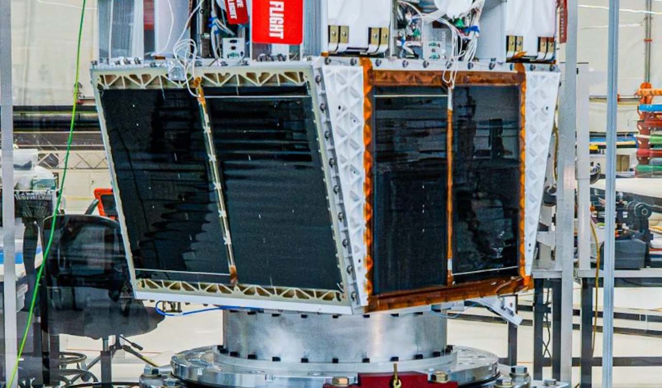 A satellite model with solar panels in a laboratory setting.