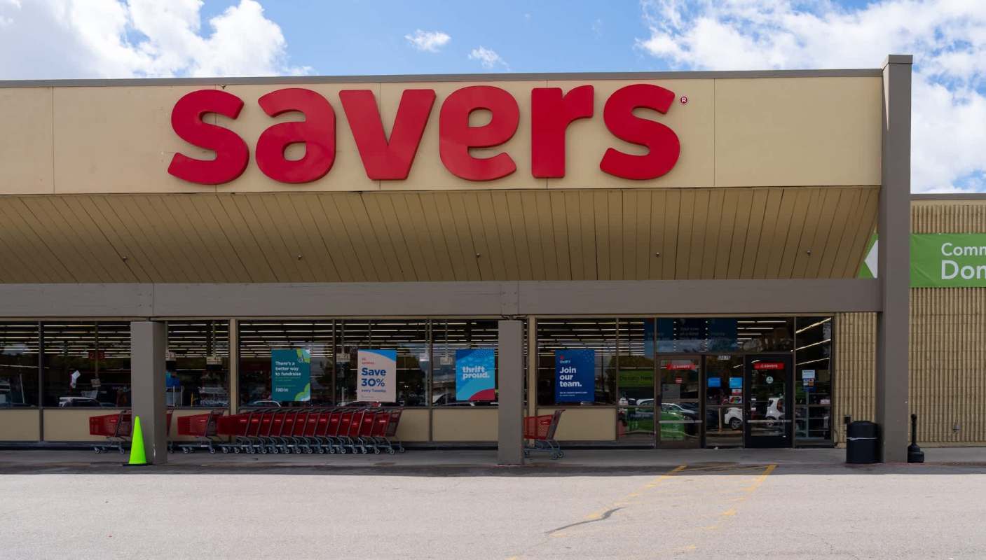 A storefront of a thrift store with red signage and shopping carts outside.