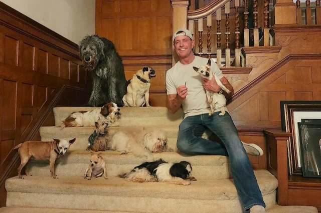 Steve Greig surrounded by senior rescue dogs.