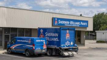 A Sherwin-Williams store with a blue delivery truck and van parked in front.