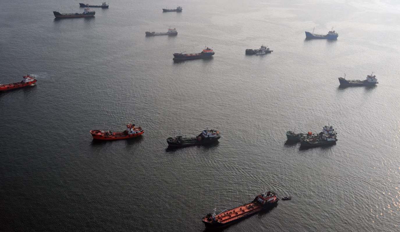 Several boats are anchored on calm water.