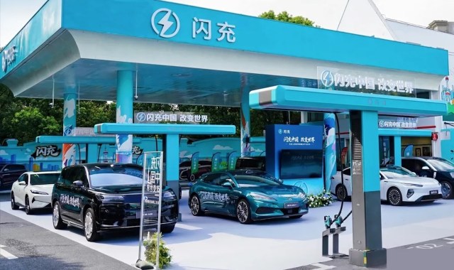 A display of electric vehicles at a charging station with a blue and white color scheme.