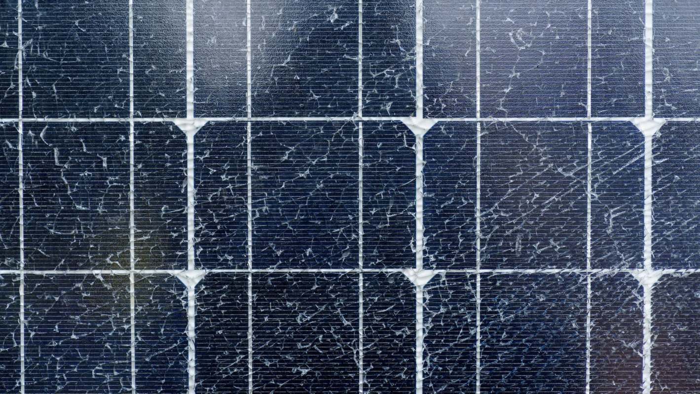 A close-up of a solar panel showing cracks and wear on the surface.