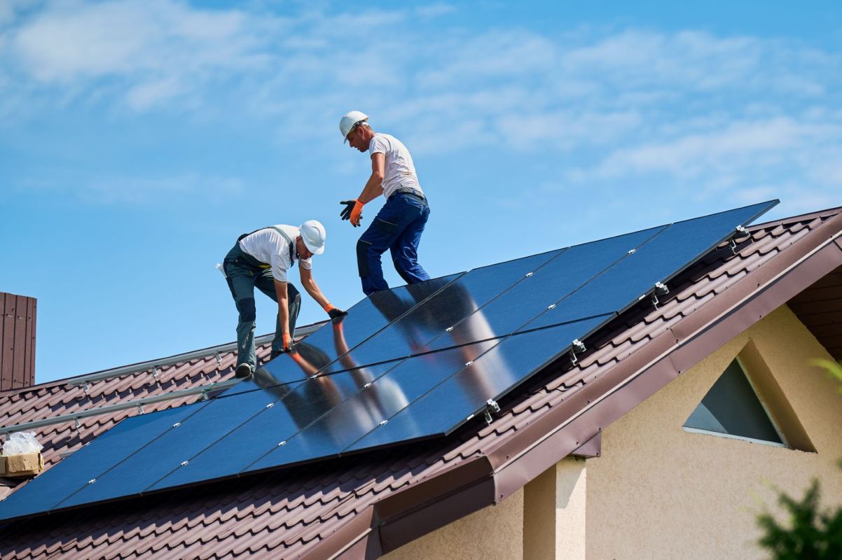 Workers installing solar panels on a roof.