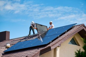 Workers installing rooftop solar.