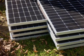 Solar panels piled on the ground.
