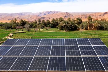 Solar panels with mountains in the background.