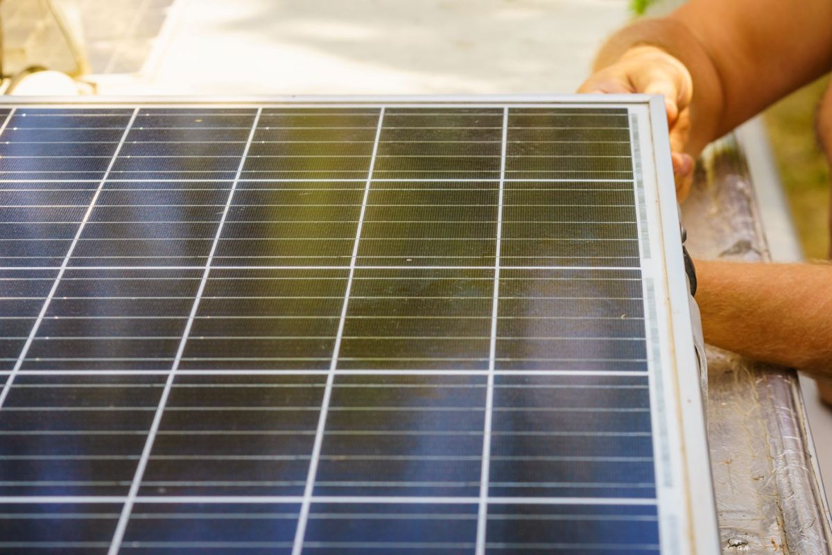 A person working on installing a solar panel.