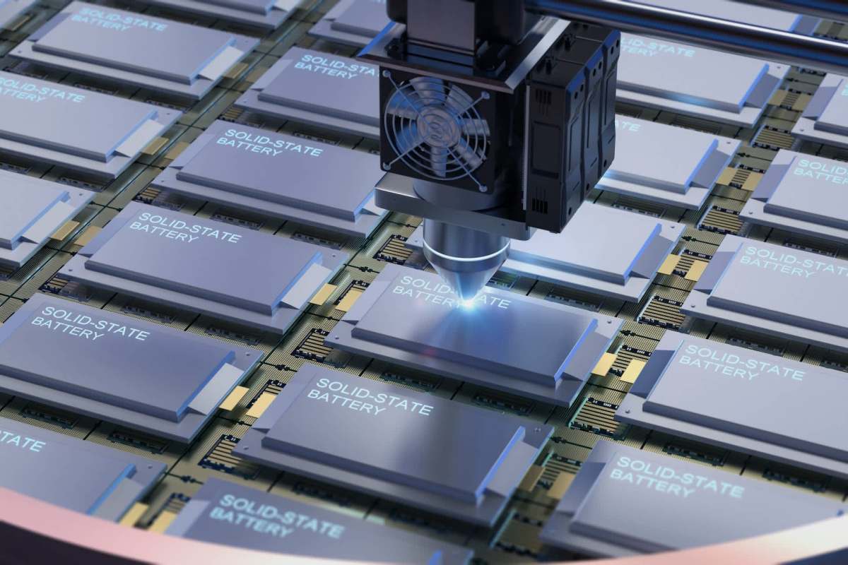 A robotic arm is placing solid-state batteries on a circuit board.