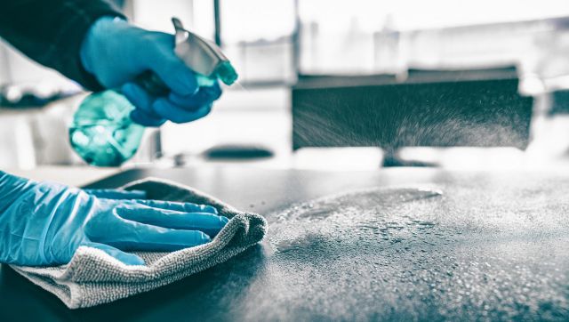 A person using disinfectant spray.
