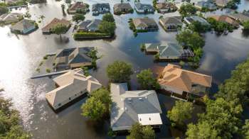 Aerial view of residential homes partially submerged in floodwaters.