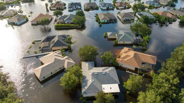 Aerial view of residential homes partially submerged in floodwaters.