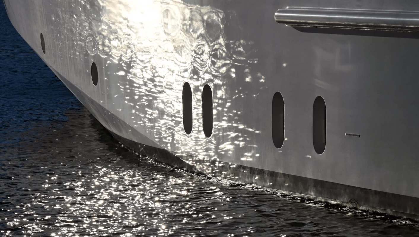 A boat hull reflecting light on the water's surface.