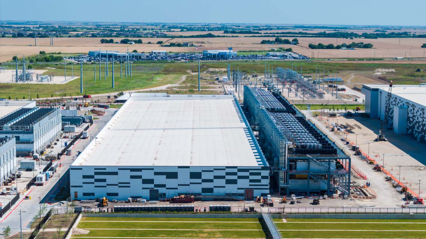 Aerial view of a large industrial facility with warehouses and equipment in a rural landscape.