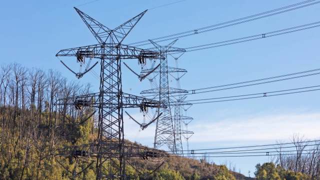 Power lines and transmission towers on a hillside.