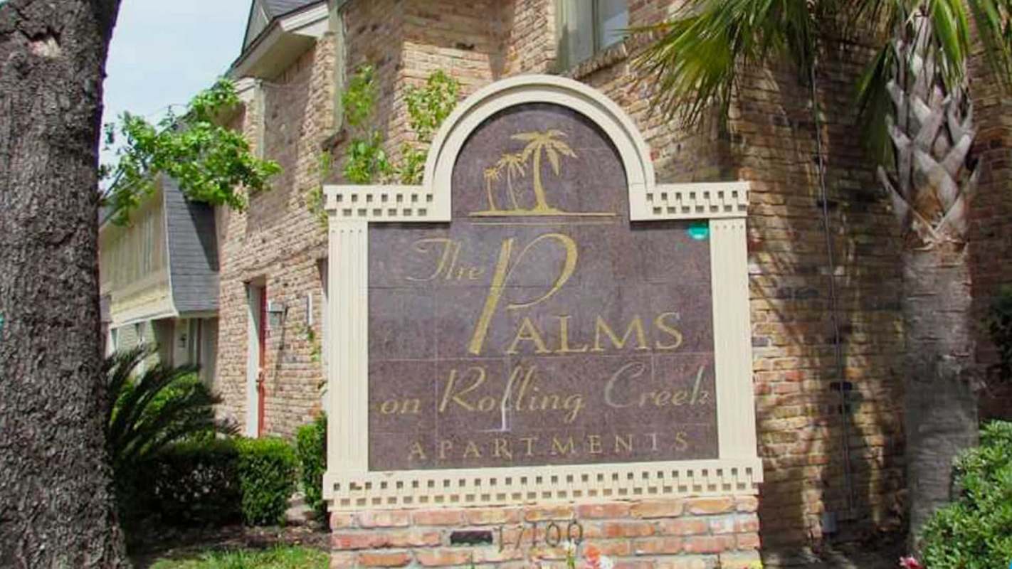 A sign for The Palms on Rolling Creek Apartments.