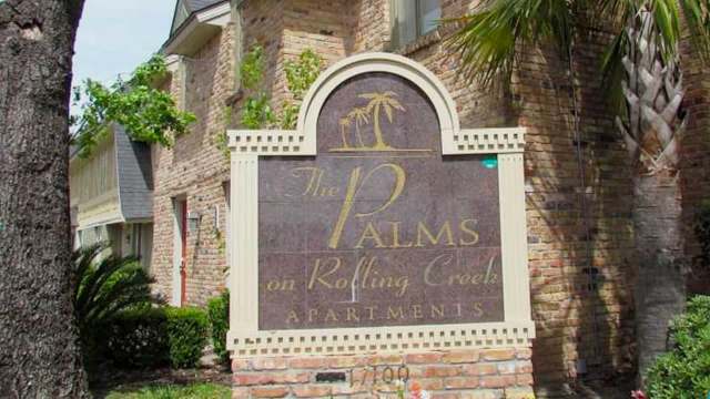 A sign for The Palms on Rolling Creek Apartments.