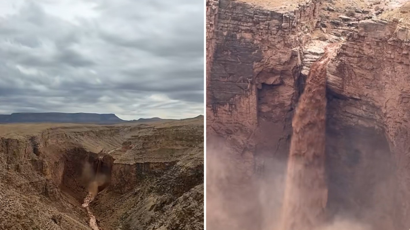 A waterfall flows over a rocky cliff into a canyon below under a cloudy sky.