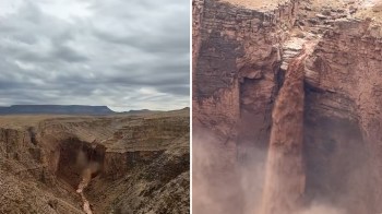 A waterfall flows over a rocky cliff into a canyon below under a cloudy sky.