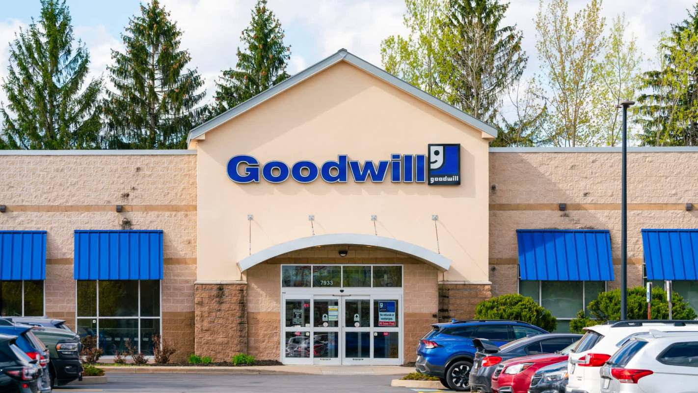 A Goodwill store with a blue awning and large glass entrance surrounded by parking.