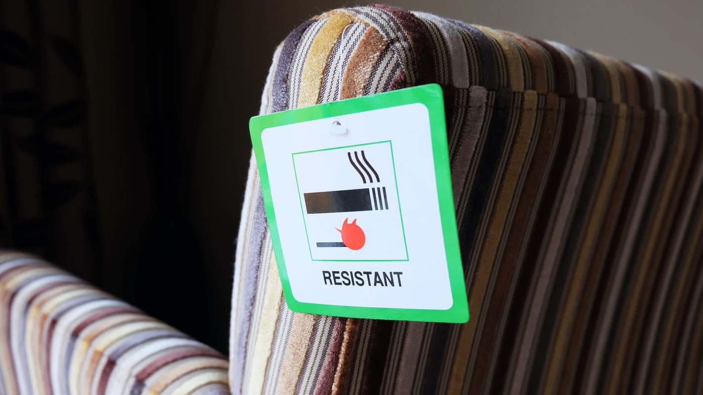 A label on a striped chair indicating it is fire resistant.