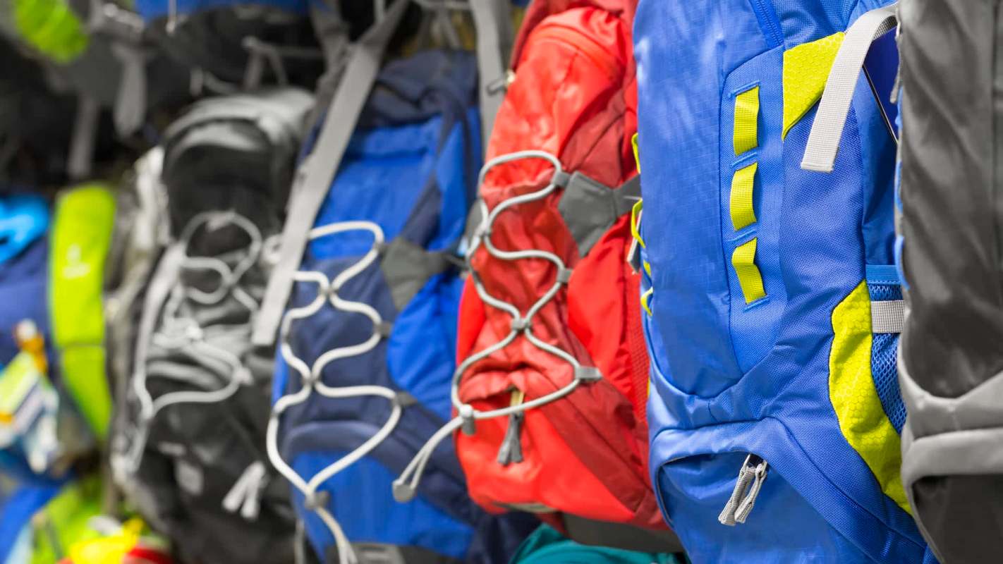 Backpacks hanging on a wall.