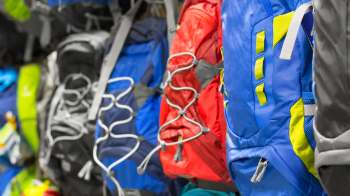 Backpacks hanging on a wall.