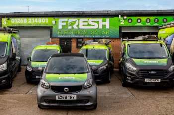 A lineup of vehicles in front of a building with a "Fresh Electrical Solar" sign.