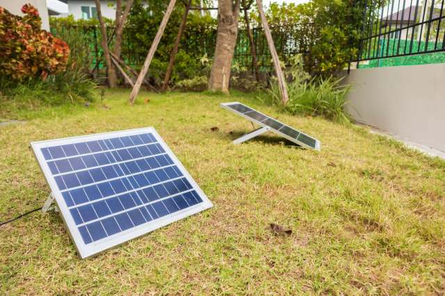 Two solar panels in a yard.