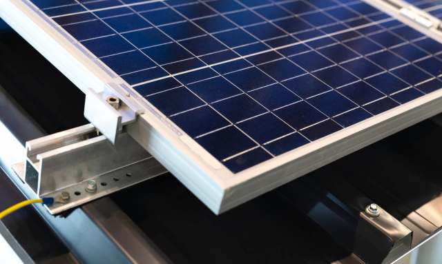 A solar panel mounted on a support structure with electrical connections visible.