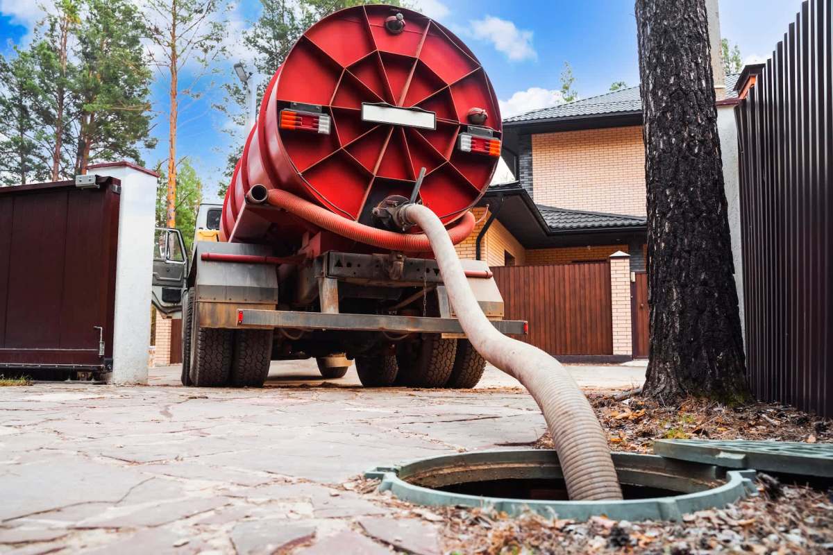 A septic tank truck servicing a sewer access point.