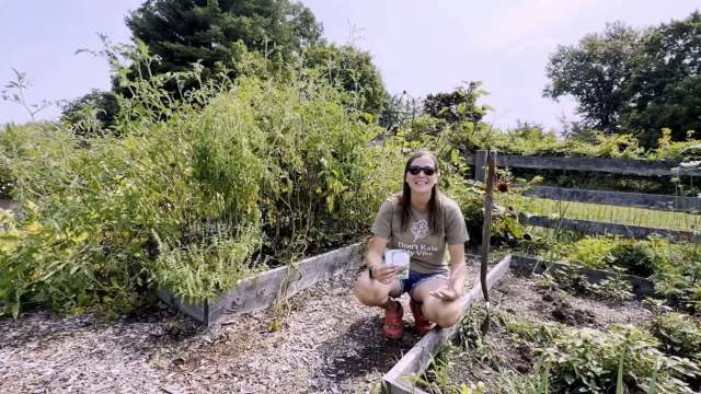 A woman crouched in a garden.