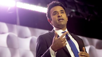 Vivek Ramaswamy gestures while speaking at a podium during an event.