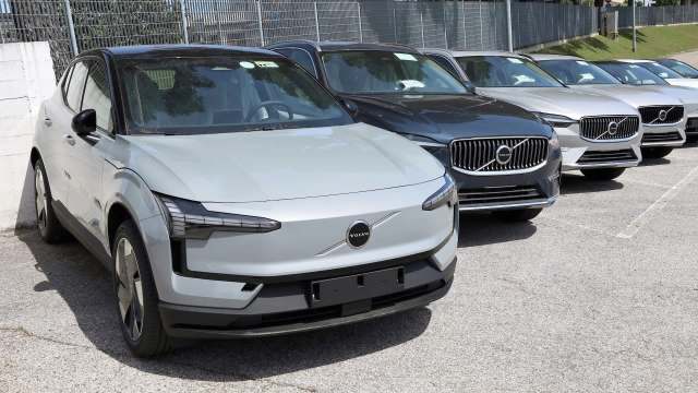 A row of various Volvo cars parked in an outdoor lot.