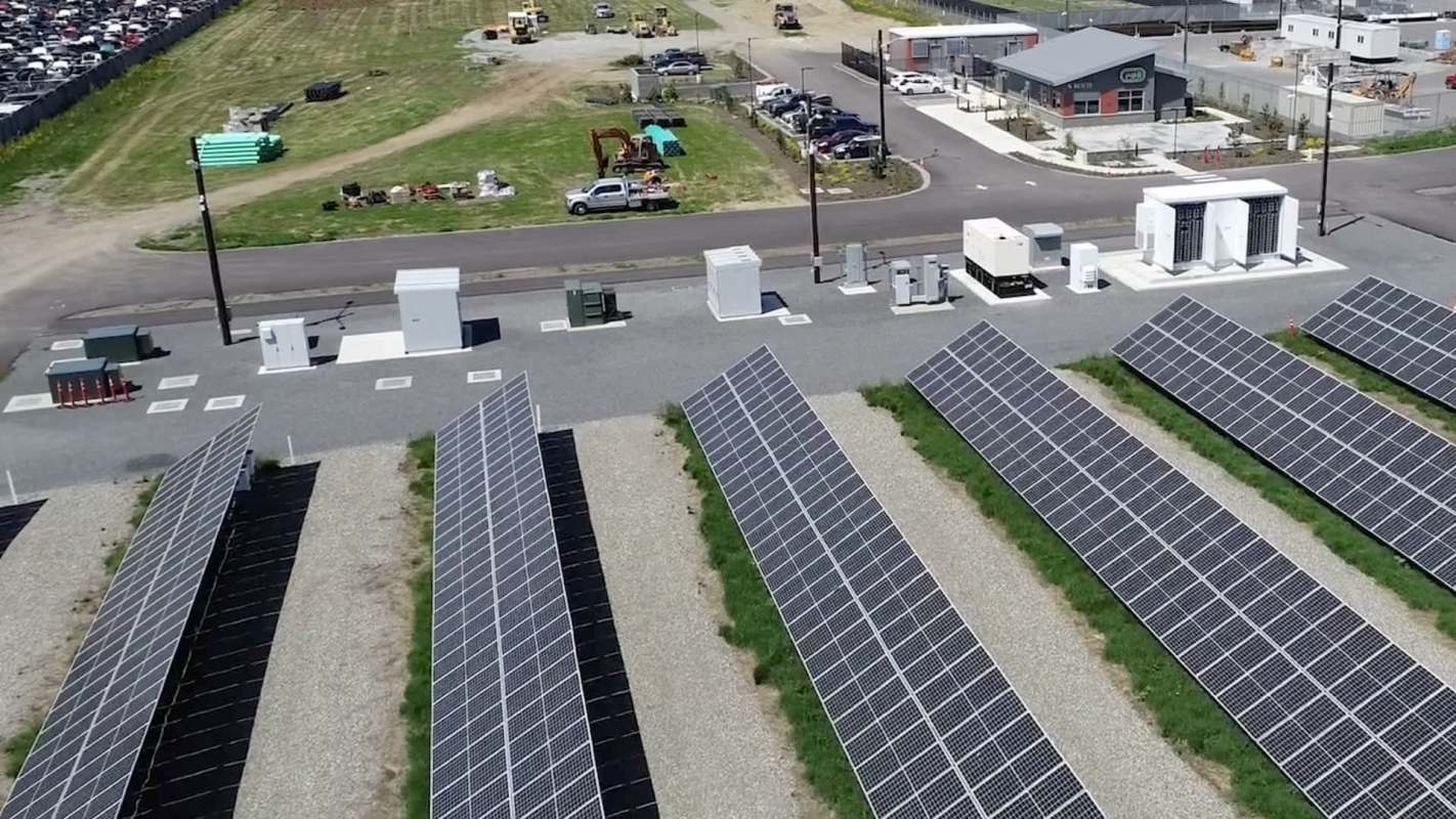 A solar panel array next to energy storage units.