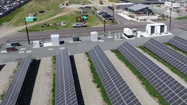 A solar panel array next to energy storage units.