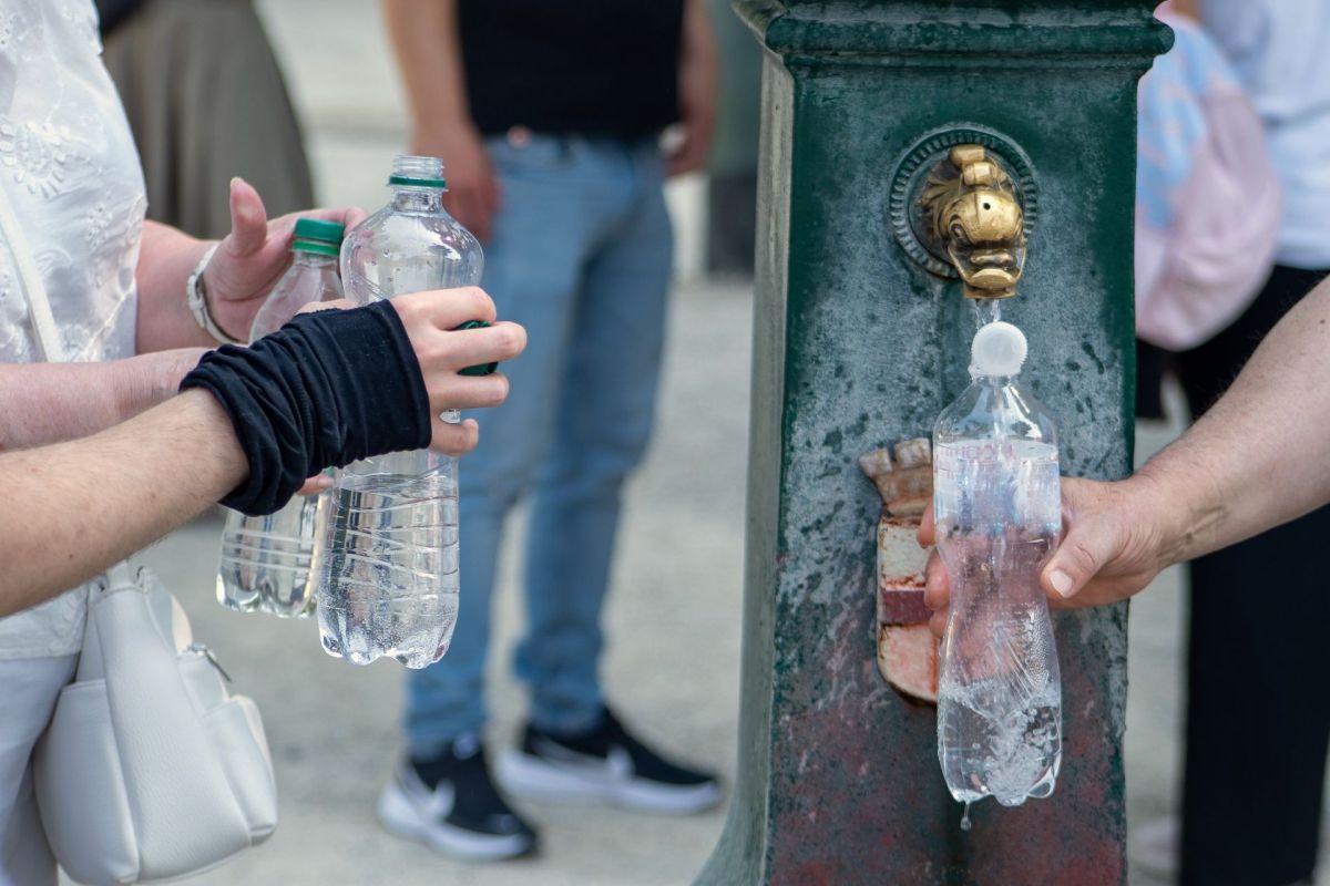 People filling up water bottles in Italy.