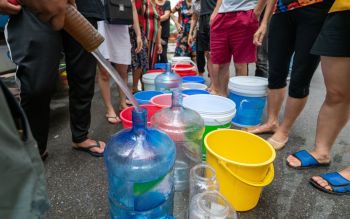 A person filling up water buckets.