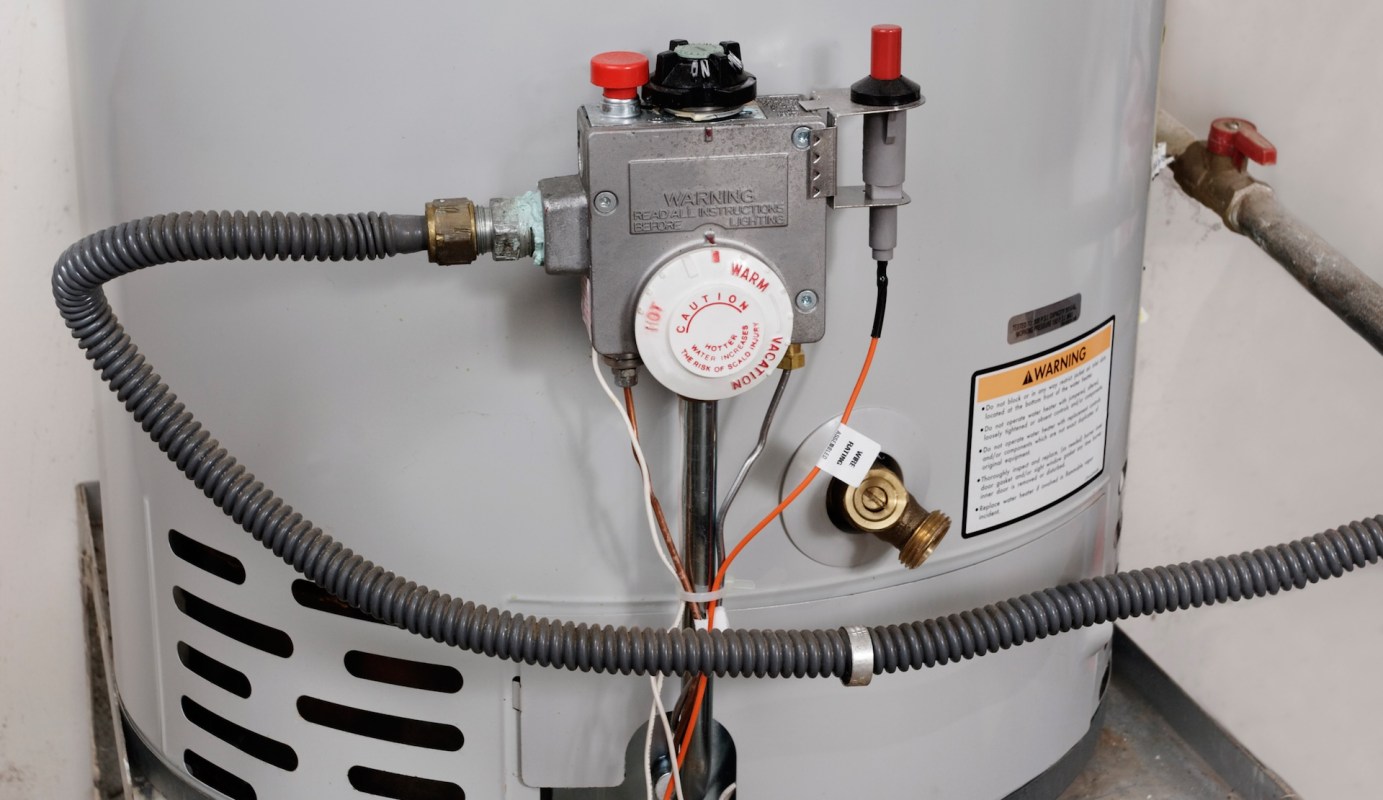 A water heater with a gas valve and various connected pipes.