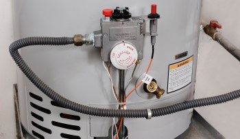 A water heater with a gas valve and various connected pipes.