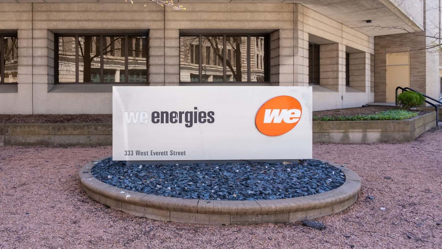 A sign for We Energies located at 333 West Everett Street, Milwaukee, in front of a modern building.