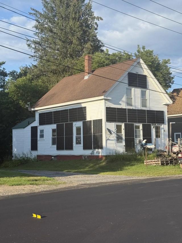 A house with multiple solar panel arrays on the outside.