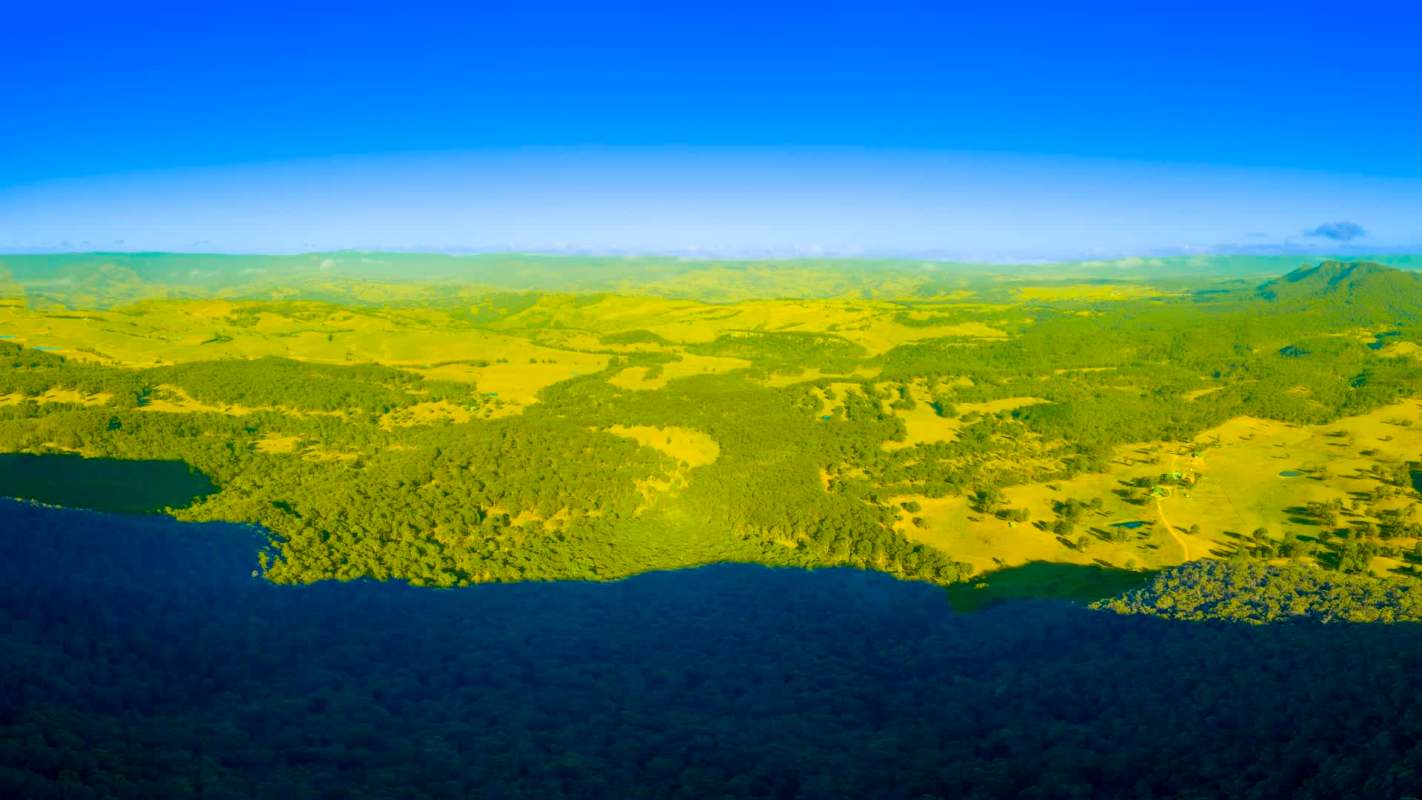 A panoramic view of rolling hills and forests near the coast.