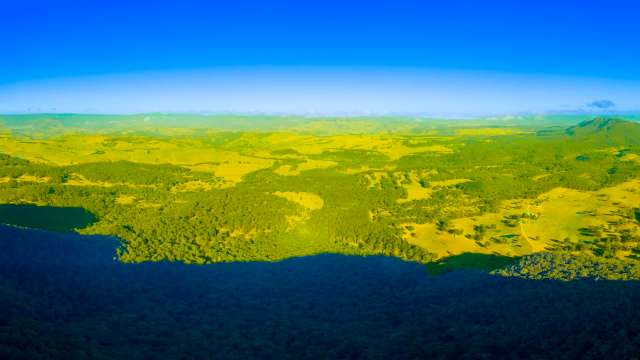 A panoramic view of rolling hills and forests near the coast.