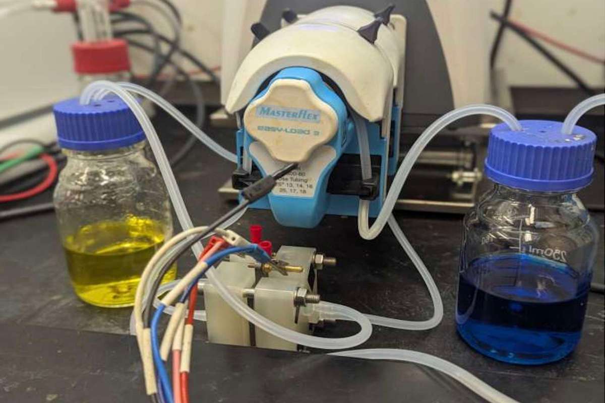 A blue MasterFlex pump connected to two containers with yellow and blue liquids.