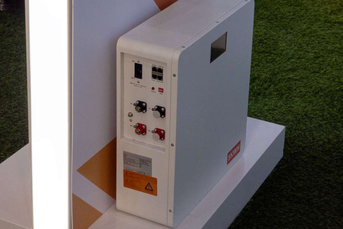A battery unit with control panel and various connectors displayed on a stand.