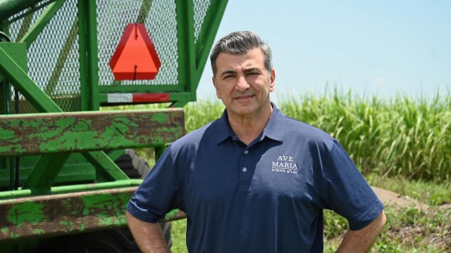 Florida Republican congressional nominee Casey Askar stands in front of farm equipment.