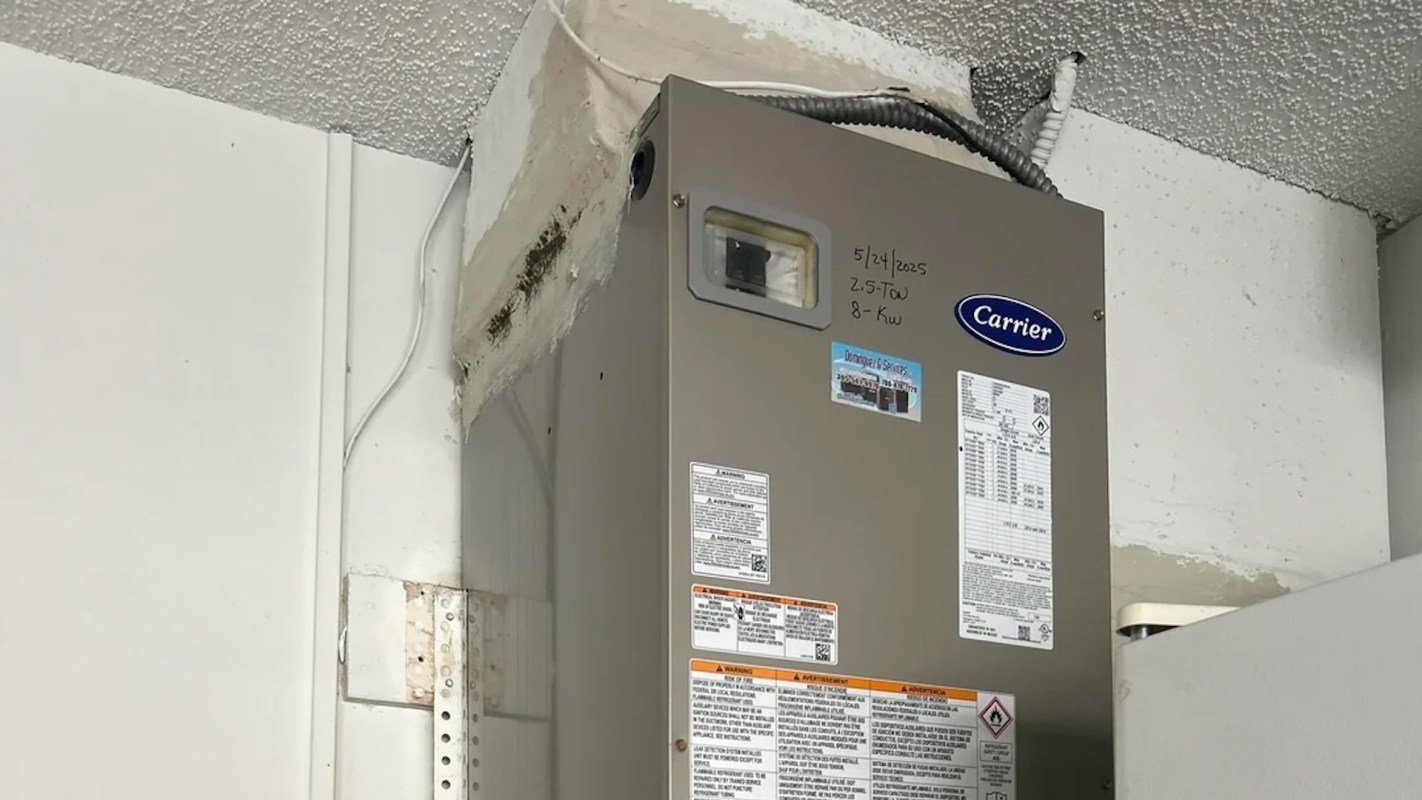 A gray heating unit mounted on a wall with visible specifications and a warning label.