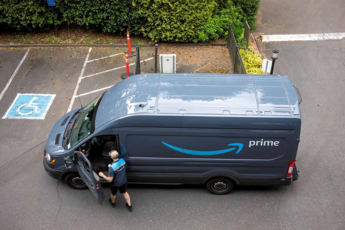 An overhead view of an Amazon delivery van and a delivery driver getting back into the vehicle