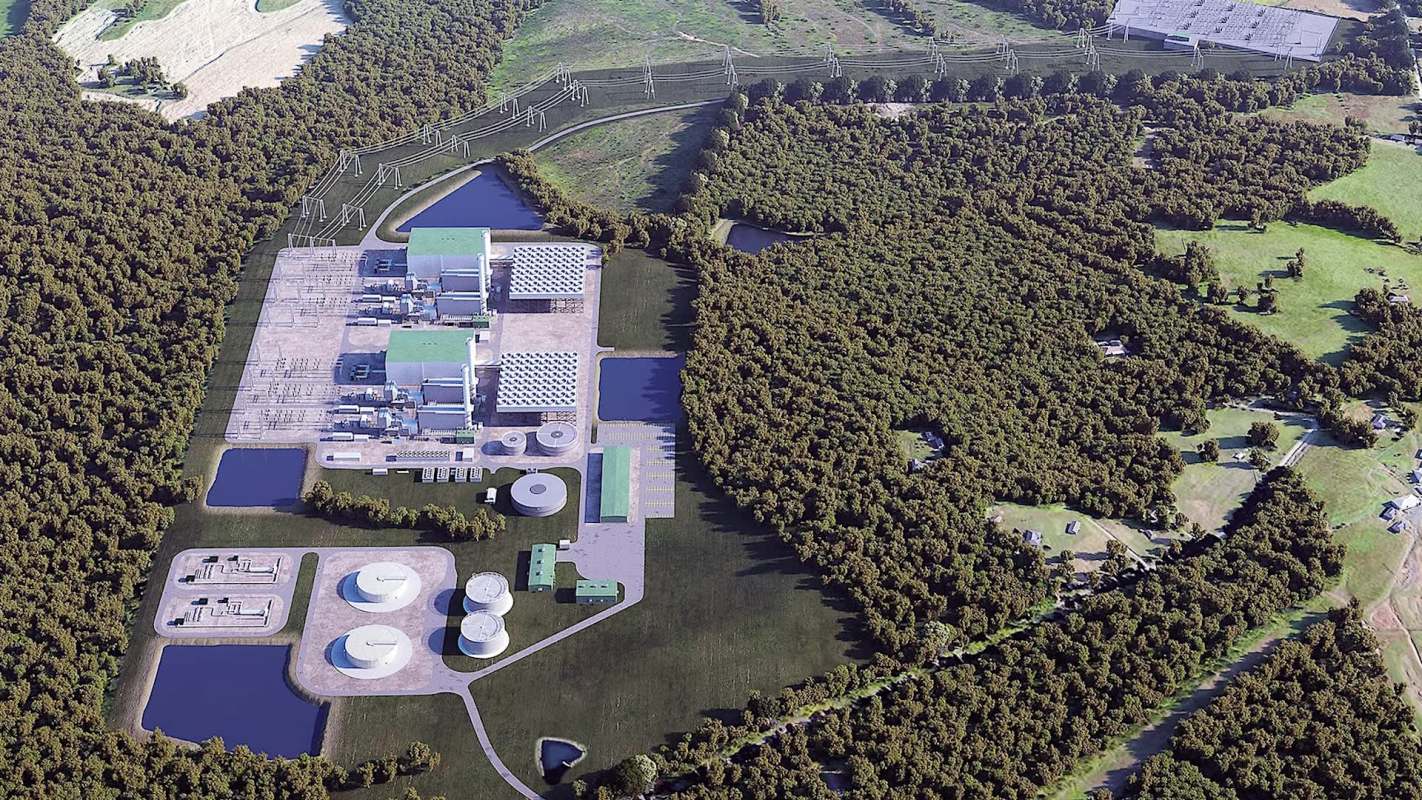 An aerial view of an industrial facility surrounded by dense forests and water bodies.